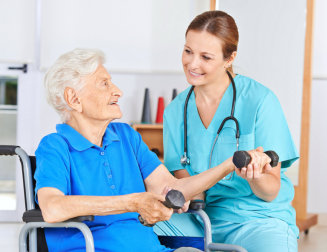 caregiver assisting senior woman in exercise