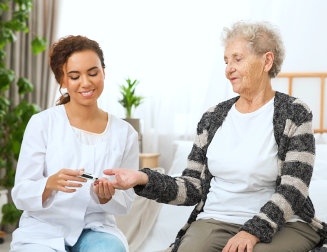 caregiver holding the hand of senior woman