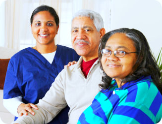 caregiver and senior couple smiling