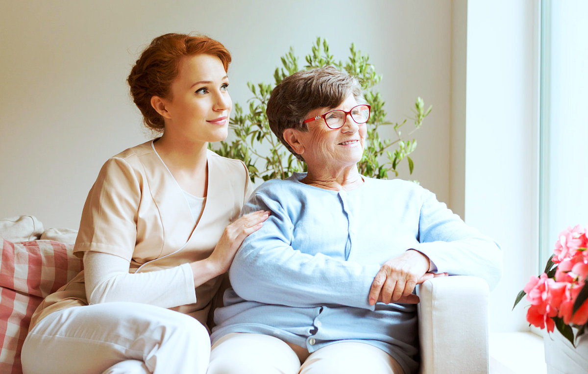 caregiver and senior woman looking outside