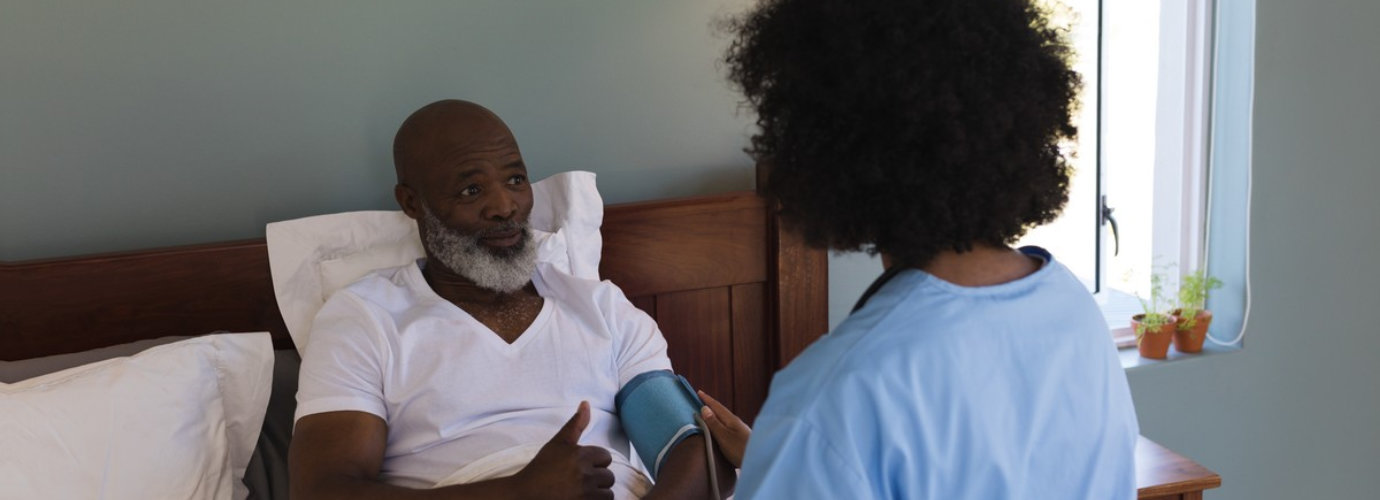 nurse monitoring the blood pressure of senior man